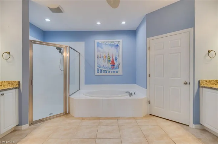 Full bath with vanity, a stall shower, a bath, recessed lighting, and light tile patterned floors