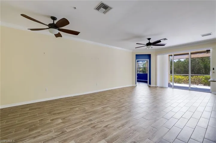Empty room featuring a ceiling fan, wood finish floors, and ornamental molding