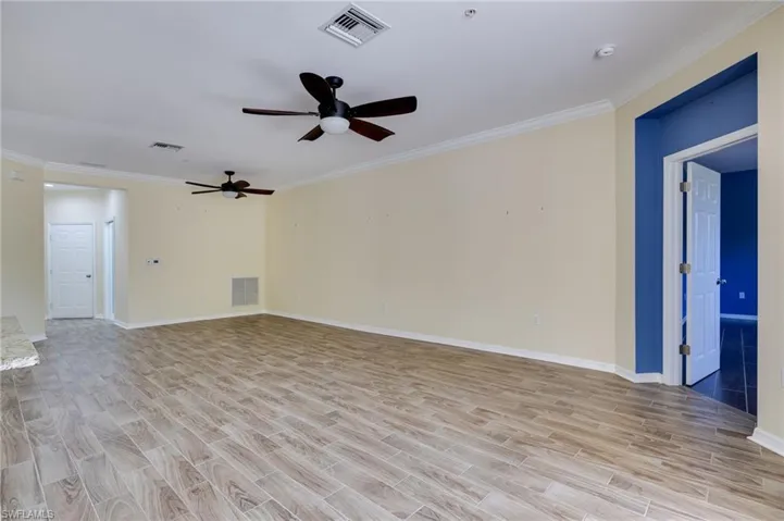 Unfurnished room featuring wood finish floors, ornamental molding, and ceiling fan