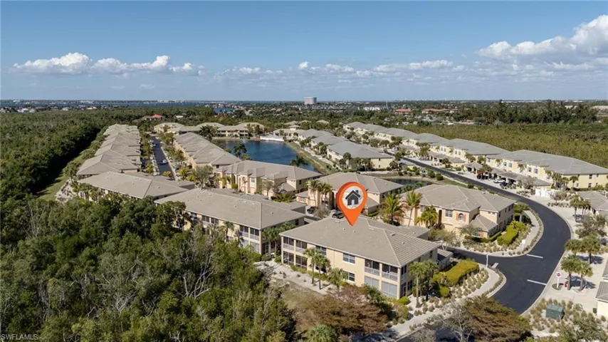 Aerial view of property and surrounding area with a nearby body of water and nearby suburban area