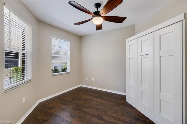 Unfurnished bedroom featuring dark wood finished floors, a closet, and ceiling fan