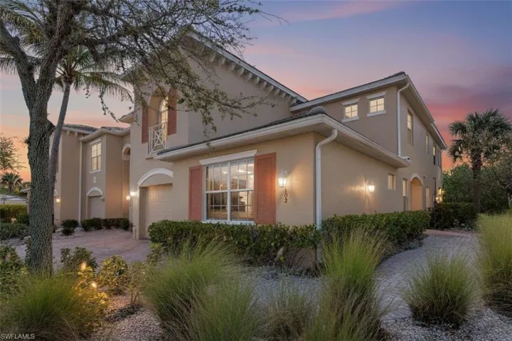 View of front of property featuring stucco siding, driveway, and a garage