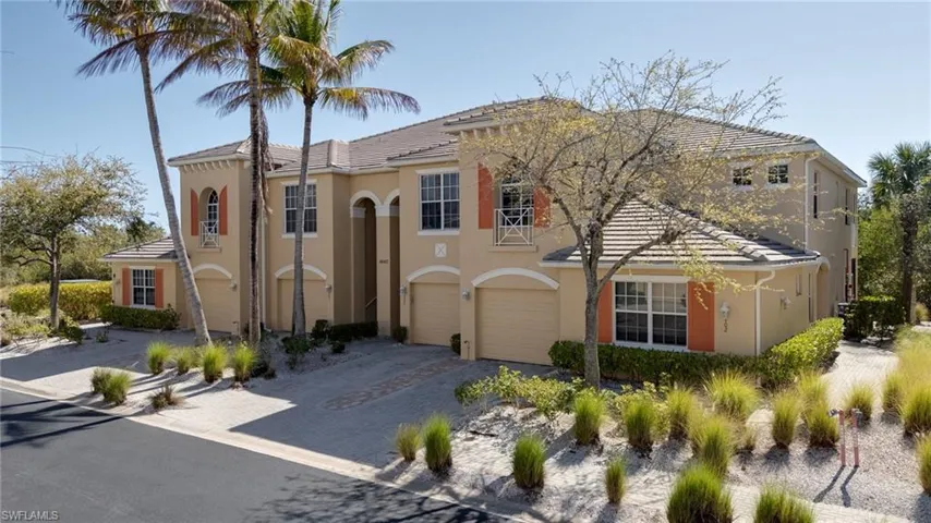 Mediterranean / spanish home featuring a tiled roof, driveway, an attached garage, and stucco siding