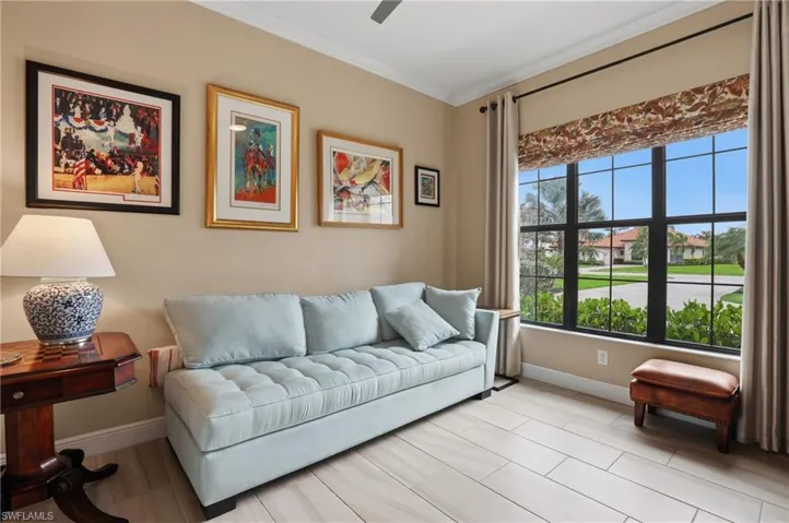 Living room with crown molding, a ceiling fan, and light wood finished floors