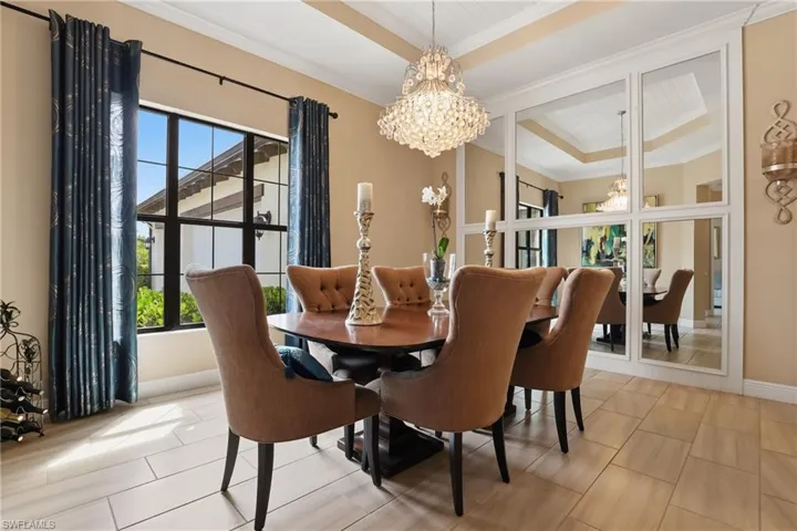 Dining area featuring hanging lights, ornamental molding, and a tray ceiling