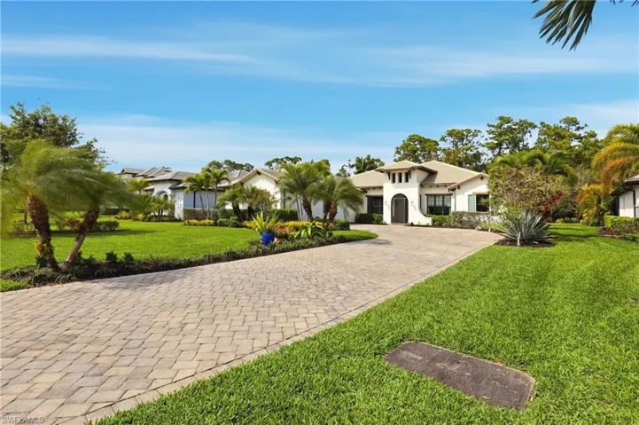 Mediterranean / spanish house featuring a front yard, decorative driveway, and stucco siding