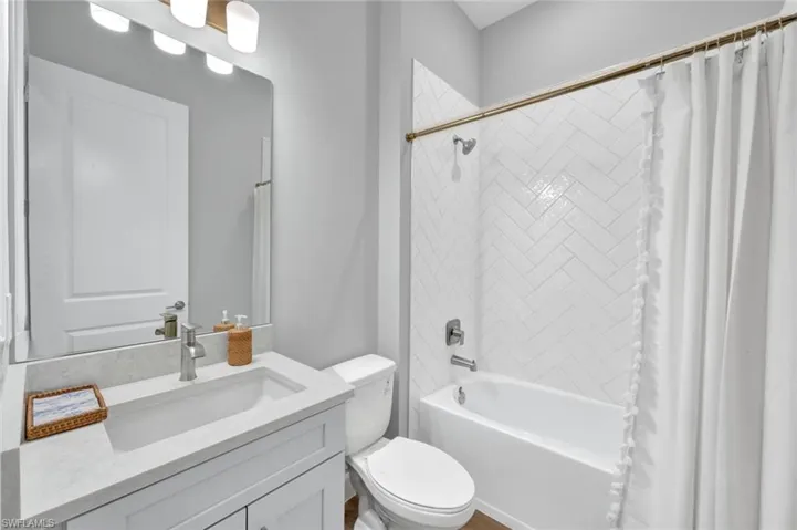 Bathroom with shower / bath combo, toilet, and vanity