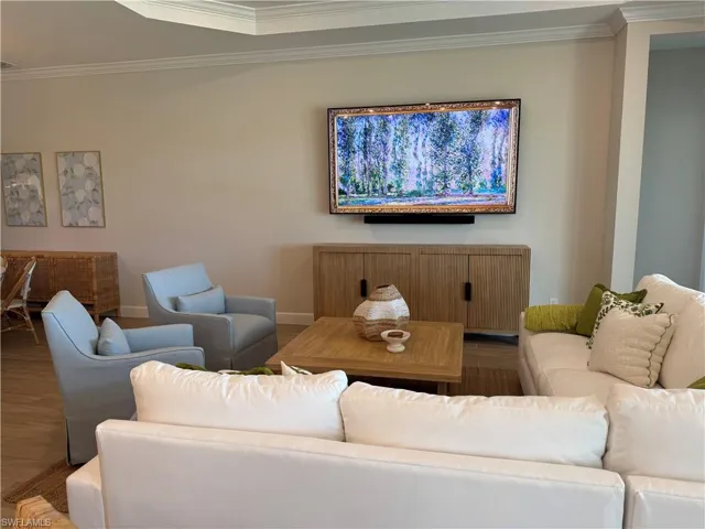 Living room featuring crown molding, wood finished floors, and baseboards