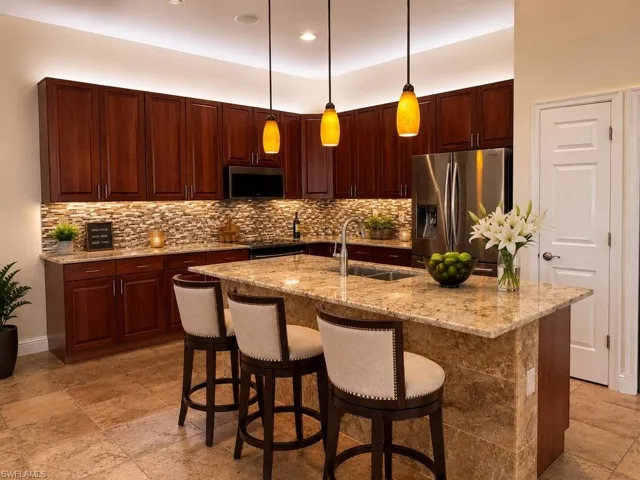 Expansive Gourmet kitchen featuring a large island with a stone countertop, dark wood cabinetry, a mosaic tile backsplash, stainless steel appliances, and tile flooring