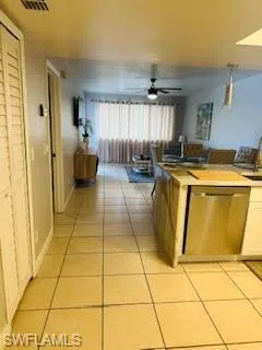 Kitchen featuring dishwasher, light tile patterned floors, a sink, and a ceiling fan