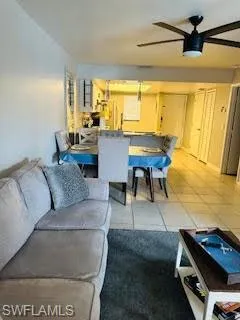 Living area with light tile patterned flooring and a ceiling fan