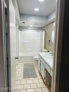Bathroom featuring shower / bathing tub combination, toilet, tile patterned floors, and vanity