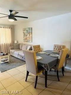 Dining area with a ceiling fan and light tile patterned flooring