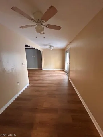 Corridor with hardwood / wood-style flooring