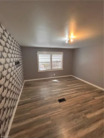Empty room featuring dark wood-type flooring