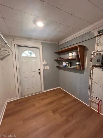 Foyer with crown molding and dark hardwood / wood-style flooring