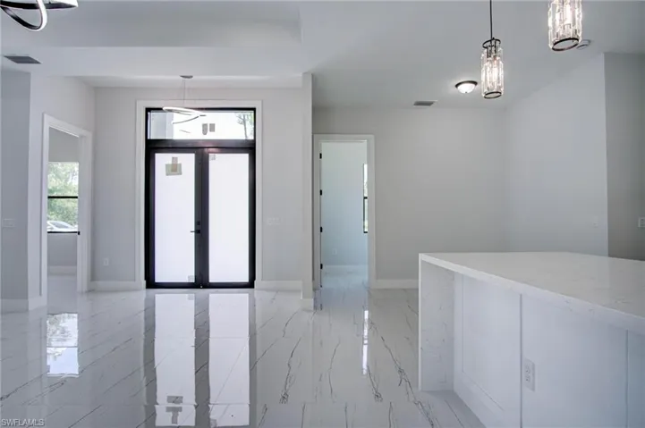 Tiled entrance foyer featuring french doors