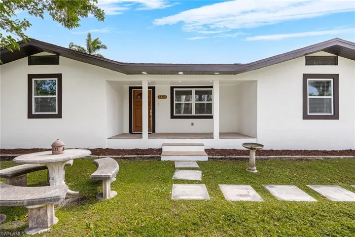 View of front facade featuring covered porch and a front lawn
