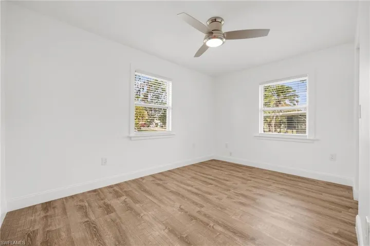 Empty room with ceiling fan and light hardwood / wood-style flooring