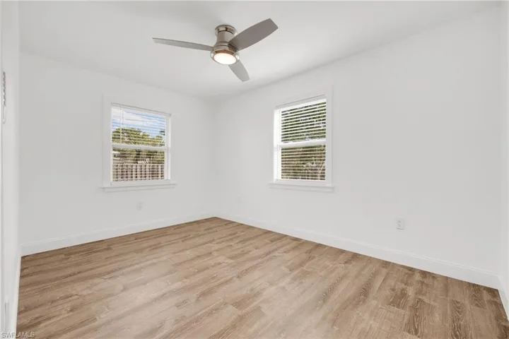 Empty room with light hardwood / wood-style floors and ceiling fan