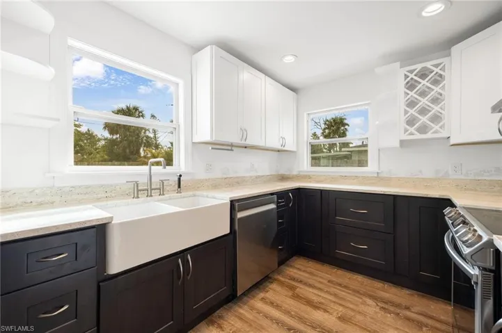 Kitchen featuring white cabinets, sink, stainless steel appliances, and light hardwood / wood-style floors