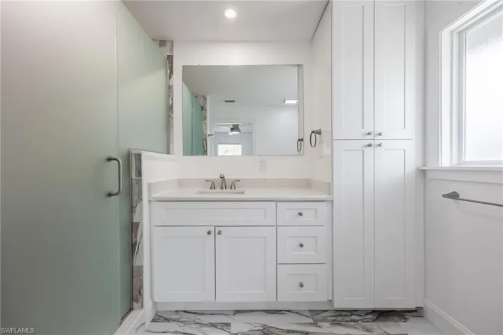 Bathroom with a shower with shower door and vanity