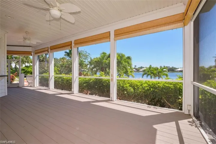 Unfurnished sunroom featuring ceiling fan and a water view