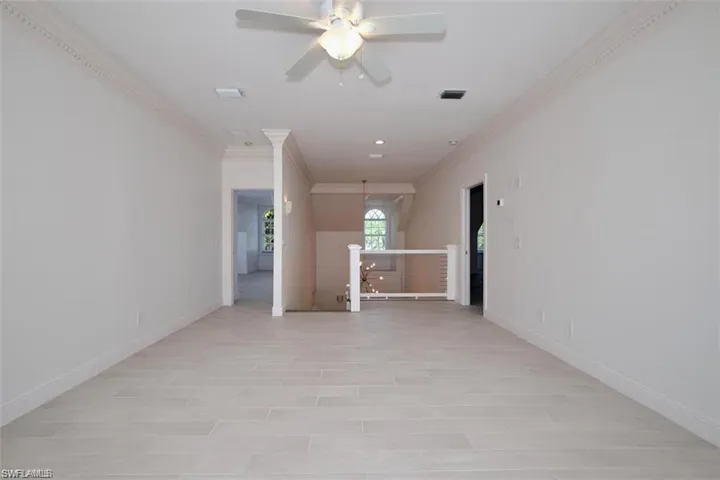 2nd floor bedroom featuring ceiling fan and crown molding