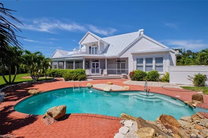 View of swimming pool with a sunroom and a patio