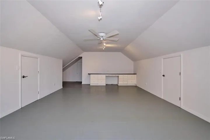 Bonus room over the garage featuring vaulted ceiling and ceiling fan