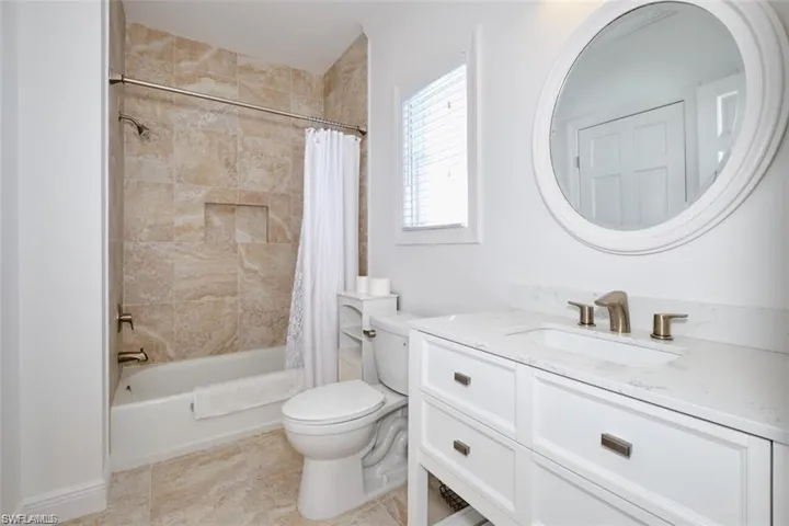 Full bathroom featuring tile patterned floors, vanity, toilet, and shower / tub combo