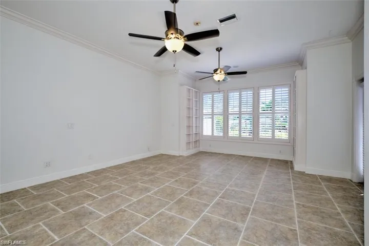 Tiled master bedroom on the 1st floor, featuring ceiling fan and ornamental molding