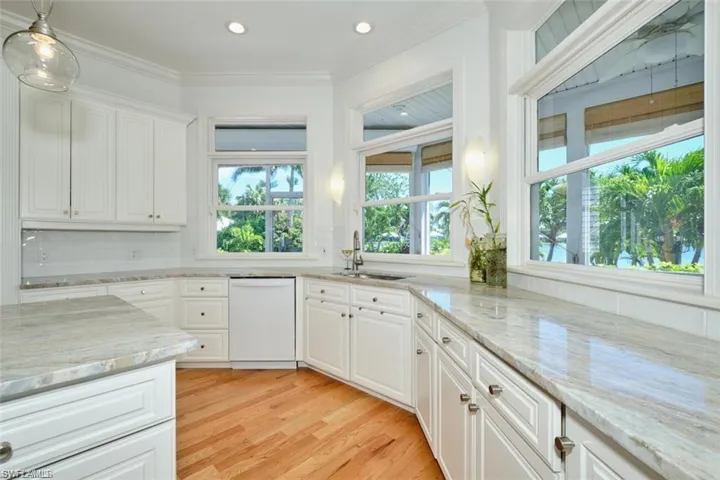 Kitchen featuring white cabinets, dishwasher, sink, and light hardwood / wood-style flooring