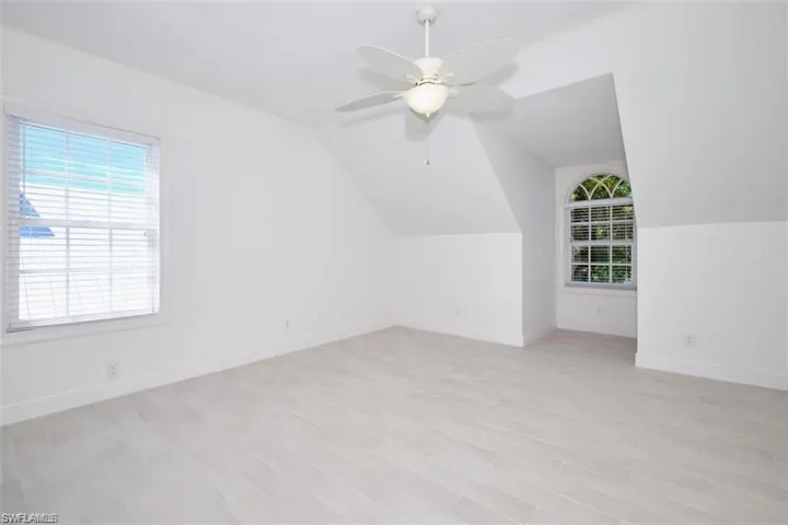 2nd floor bedroom with ceiling fan, light hardwood / wood-style flooring, and lofted ceiling