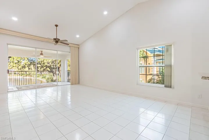 Empty room featuring high vaulted ceiling, light tile patterned flooring, recessed lighting, and ceiling fan