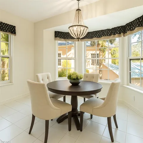 Virtually staged tiled dining space with baseboards and a chandelier