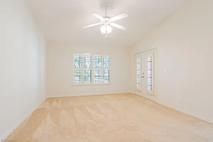 Carpeted spare room with lofted ceiling and ceiling fan