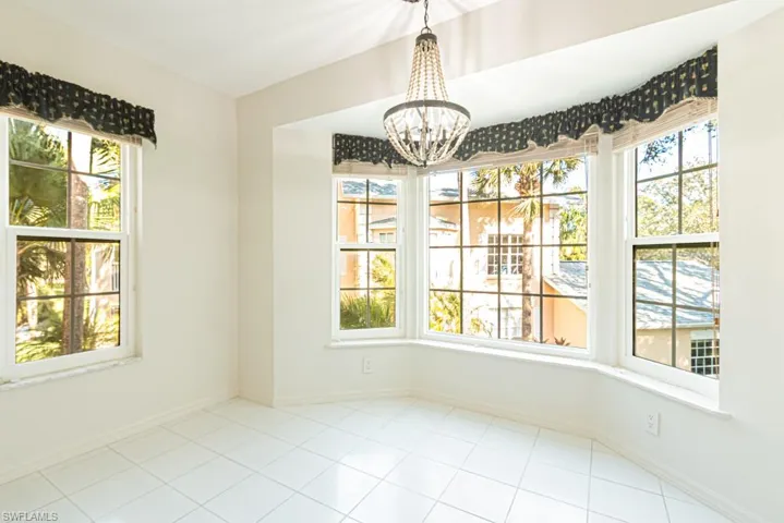 Unfurnished dining area with a chandelier and light tile patterned floors