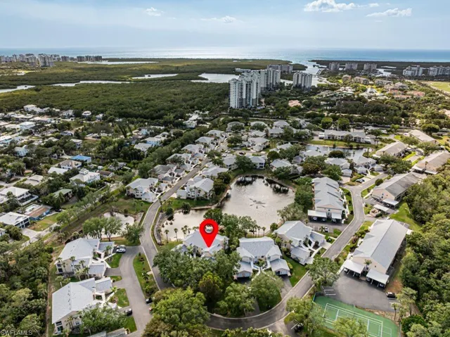 Aerial view of property's location featuring a nearby body of water and nearby suburban area