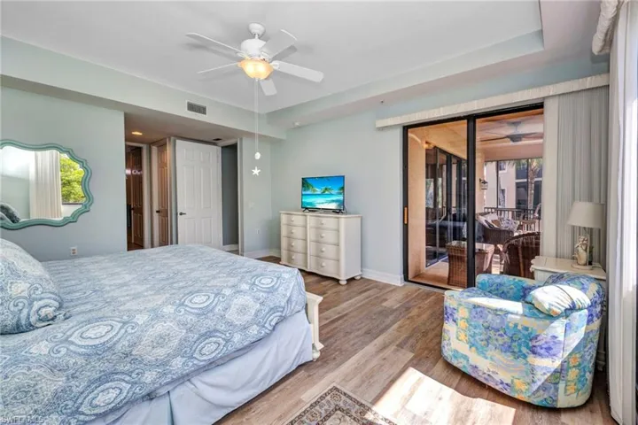 Bedroom featuring access to outside, wood finished floors, and ceiling fan