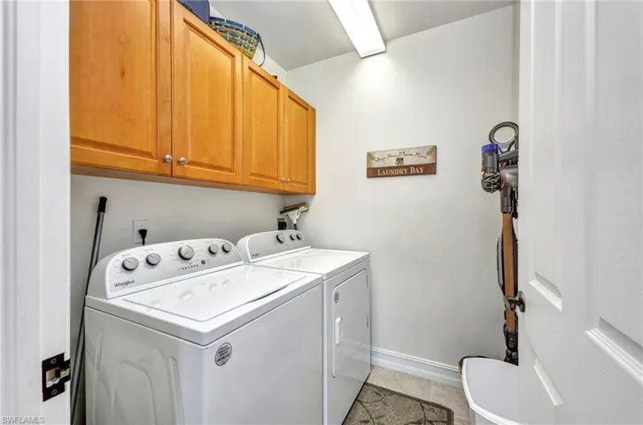 Laundry area featuring cabinet space, separate washer and dryer, and light tile patterned floors