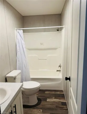 Full bathroom featuring vanity, dark wood-style flooring, and shower / bath combo