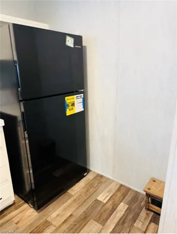 Kitchen view of freestanding refrigerator and light wood-style flooring