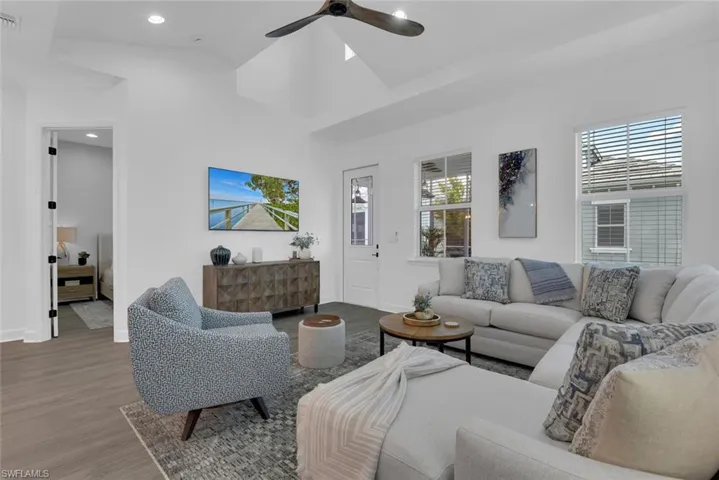 Living area featuring visible vents, ceiling fan, baseboards, and wood finished floors