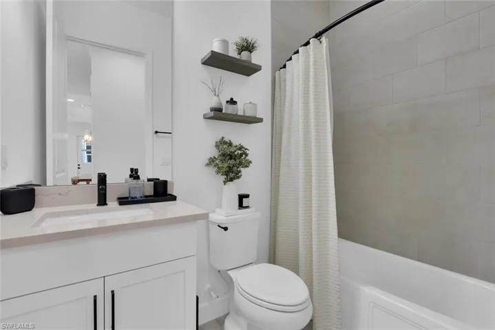 Full bath with toilet, shower / bath combo, and vanity