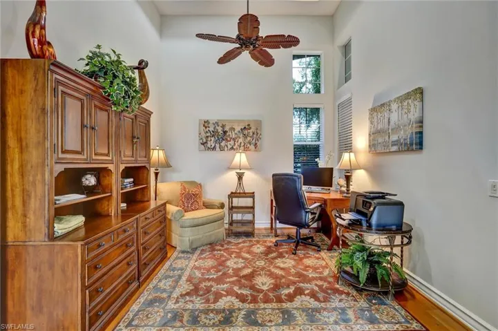 Vaulted ceiling office space featuring wood-finish flooring
