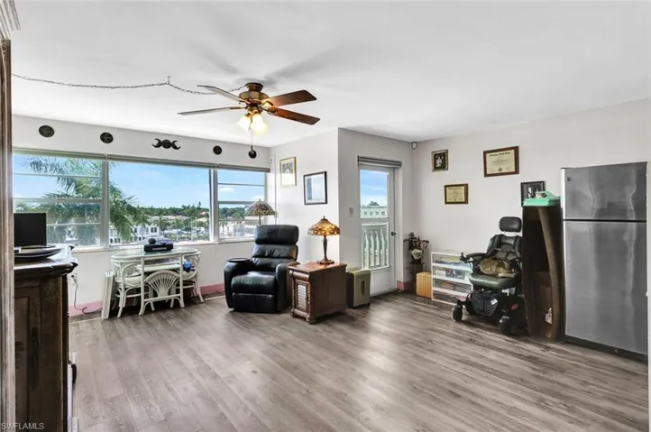 Living room with ceiling fan and hardwood / wood-style floors