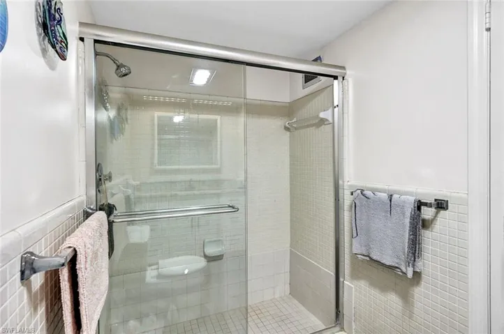 Bathroom with tile walls and an enclosed shower