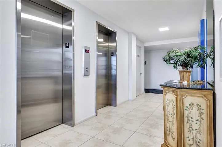 Hall with light tile patterned flooring and elevator
