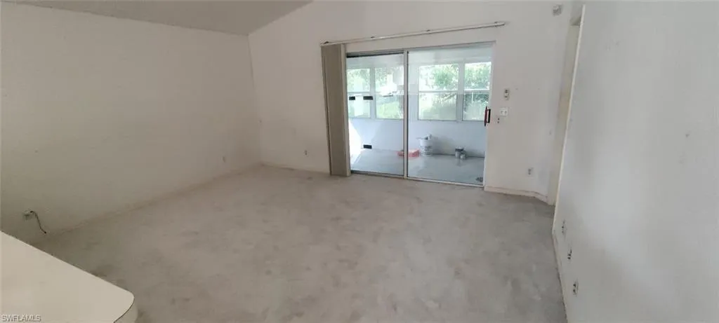 Empty room featuring lofted ceiling and light carpet